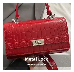 Close-up of red crocodile pattern leather handbag with silver metallic rotary lock