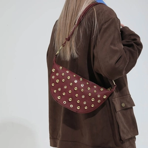 Close-up of crescent moon shoulder bag in burgundy leather with gold metal studs details