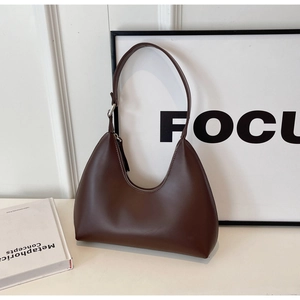 Gros plan du sac sous le bras en forme de lune marron avec boucle en argent poli