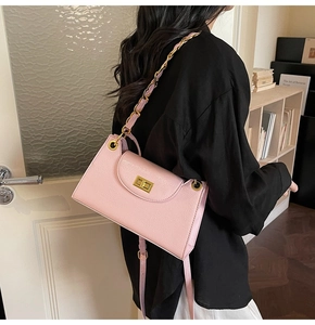Détail du sac bandoulière rose montrant le fermoir doré et le grain du cuir