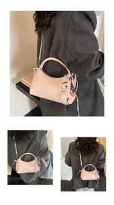 Detalle del bolso de cuero rosa con colgante de caballo y correa ajustable