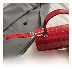 Detail of red crocodile texture bag showing silver metal swivel hook and premium hardware