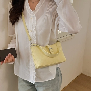 Detail of yellow PU leather shoulder bag featuring a silver metal buckle and micro-wrinkled texture