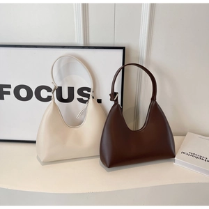 Vue détaillée des textures de sac hobo en crème et marron avec finition cuir mat lisse