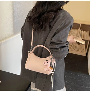 Detalle del bolso de cuero PU rosa con un elegante colgante de caballo y cierre de cremallera