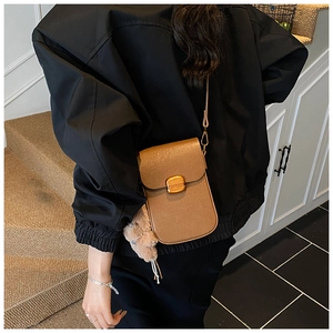 Brown faux leather crossbody phone bag with gold clasp and plush pendant accessory