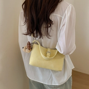 Pale yellow ruched leather shoulder bag with silver buckle and plush puppy charm detail