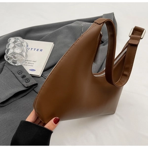 Gros plan détaillé du sac croissant marron montrant les coutures et le zip argenté