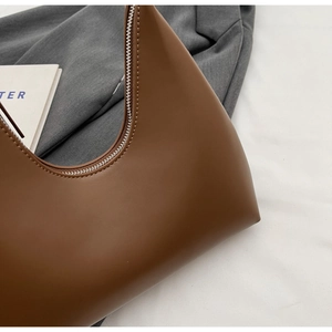 Vue détaillée du sac hobo marron foncé montrant les coutures fines et le cuir lisse