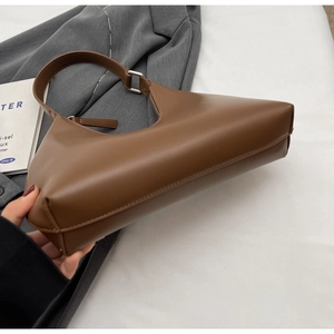 Détail d'un sac hobo en cuir marron avec des boucles métalliques rectangulaires argentées