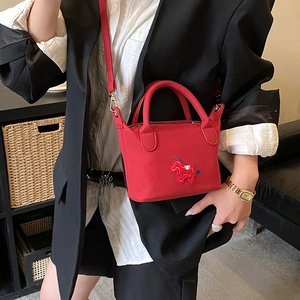 Mini-Beuteltasche in Rot mit Pferde-Stickerei als Umhängetasche für Damen präsentiert