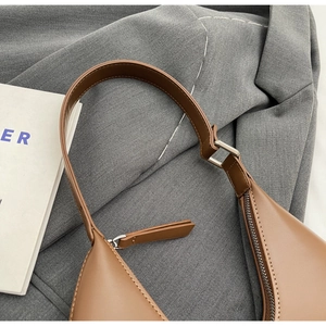 Détails du sac porté épaule en cuir marron avec surpiqûres blanches contrastées
