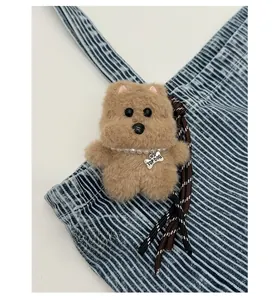 Detail of plush dog keychain with pearl necklace and engraved TOP DOG bone pendant
