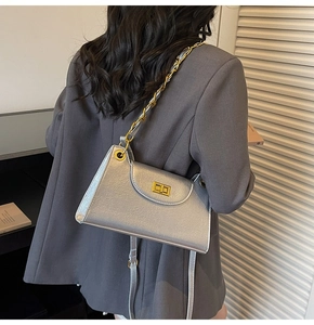 Vue détaillée d'un sac argenté à chaîne avec fermoir doré et œillets métalliques au dos