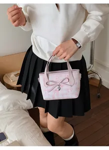 Pink tote bag with bear print featuring a 3D bow and heart charm in a lifestyle setting