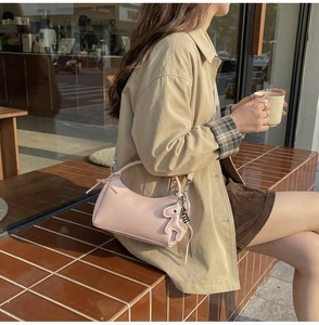 Bolso de media luna rosa pálido en cuero sintético con colgante de caballo y modelo