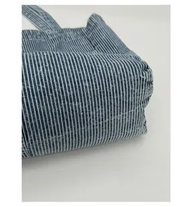 Close-up of blue and white striped denim canvas tote bag with soft fabric texture