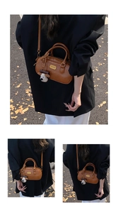 Detail view of brown vintage leather bowling bag with gold logo and plush sheep charm