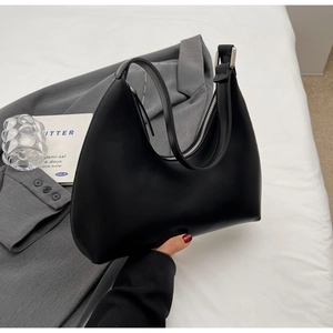 Détail du sac demi-lune noir avec fermeture éclair argentée et texture en cuir