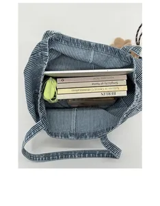 Top view of striped canvas tote bag showing large interior capacity with books and tablet