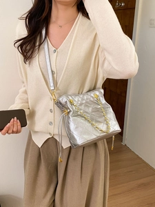 Détail du sac seau matelassé argenté avec chaîne dorée et logo PANTONE LONDON
