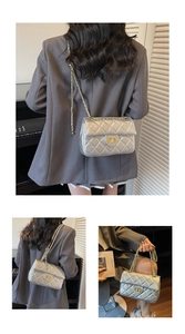 Detail of silver quilted crossbody bag with gold chain strap and luxury turn-lock closure