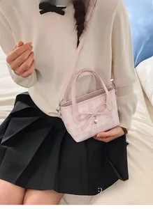 Close-up of pink checkered tote bag featuring a large bow and heart charm detail