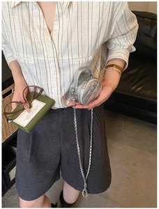 Détail du mini sac rond argenté matelassé avec finition métallisée et bandoulière