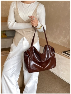 Detail view of large dark coffee faux leather tote bag with glossy finish and rivets