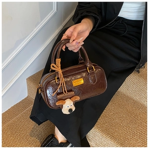 Detail of vintage brown bowling bag with glossy wrinkled texture and golden hardware
