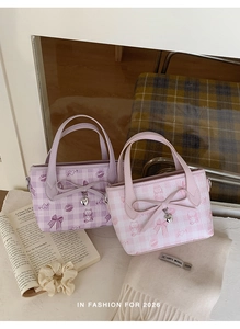 Close-up of sweet plaid mini handbags with cute bear prints and heart pendants