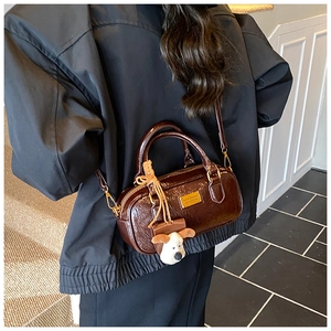 Detail of vintage brown bowling bag with glossy leather texture and cute puppy charm
