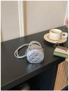 Vue détaillée du mini sac rond argenté avec motif matelassé et décoration de fleur