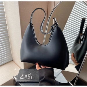 Vue en miroir d'un sac à bandoulière hobo noir mat au design minimaliste