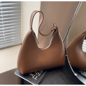 Détail du sac hobo en cuir marron avec bandoulière réglable et ferrures métalliques