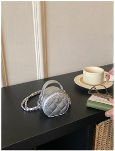 Vue détaillée du mini sac argenté matelassé avec ornement fleur et chaîne