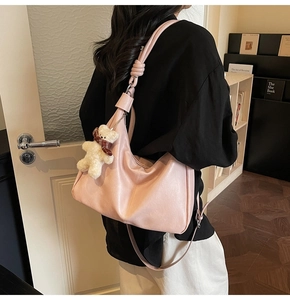 Pink soft leather hobo bag with unique knotted strap and cute white bear charm