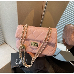Macro shot of pink quilted leather shoulder bag with gold chain and metal twist lock