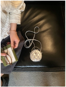 Détail du mini sac rond matelassé argenté avec logo camélia et bandoulière chaîne