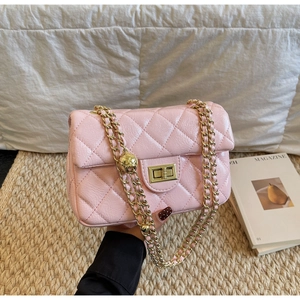 Detail of pink quilted patent leather bag with gold chain strap and adjustable ball charm