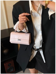 Detail of pink croc-embossed mini handbag with silver square rotary lock and handle