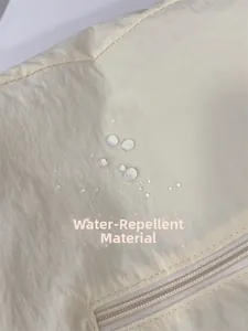 Gros plan du tissu imperméable avec gouttes d'eau et fermeture éclair sur le sac fourre-tout
