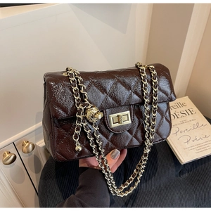 Close-up of brown quilted patent leather bag with gold chain strap and metal turn-lock