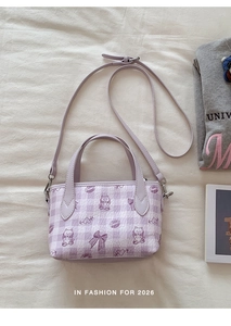 Macro shot of purple checkered handbag with cute cat prints and silver hardware detail