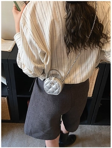 Mini sac rond argenté matelassé avec détail d'emblème en métal en forme de camélia