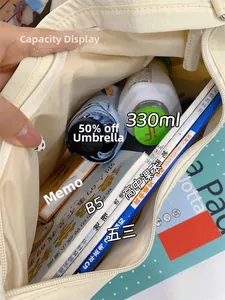Intérieur spacieux du sac fourre-tout ivoire montrant le rangement pour livres et parapluie