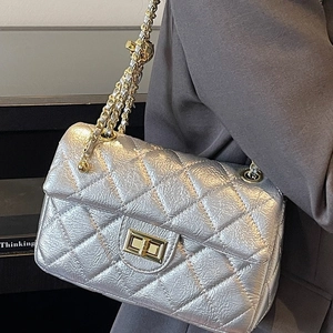 Silver quilted chain shoulder bag with gold turn-lock closure and leather strap details