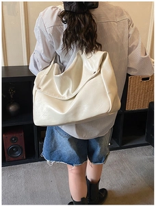 Close-up of cream white large tote bag with silver metallic studs in a lifestyle setting