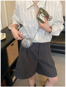 Détail d'un mini sac argenté matelassé avec boucle camélia et bandoulière en chaîne