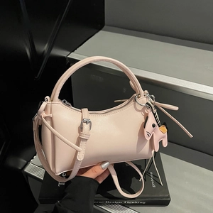 Elegante bolso de media luna rosa claro con asa redonda y colgante de poni decorativo